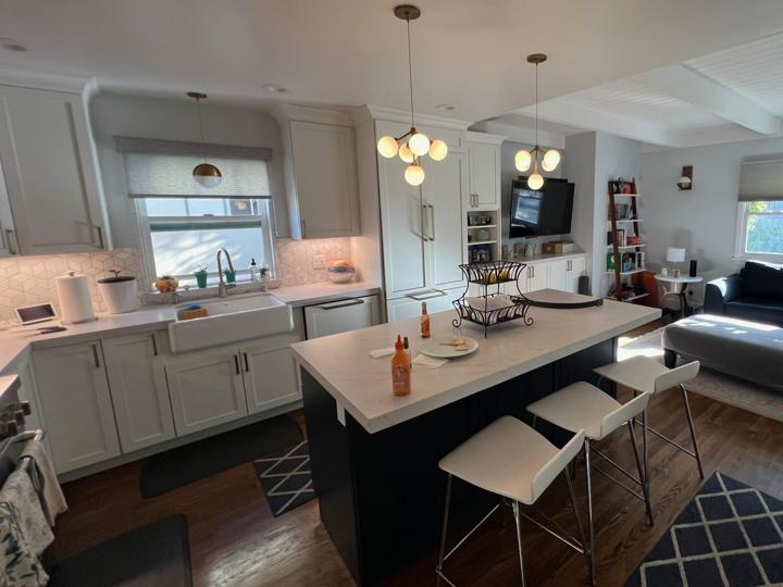 Open kitchen with island and family room with beamed ceiling